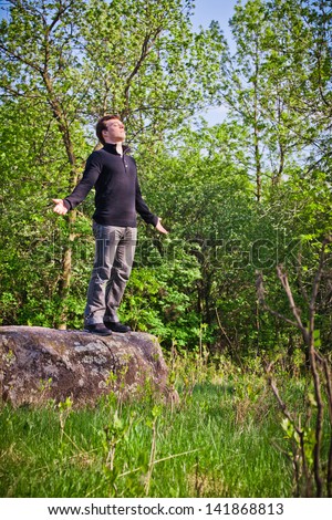 Man standing up on the rock in the forest