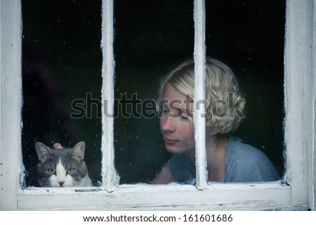 Woman And Cat Looking At The Rainy Weather By The Window Frame
