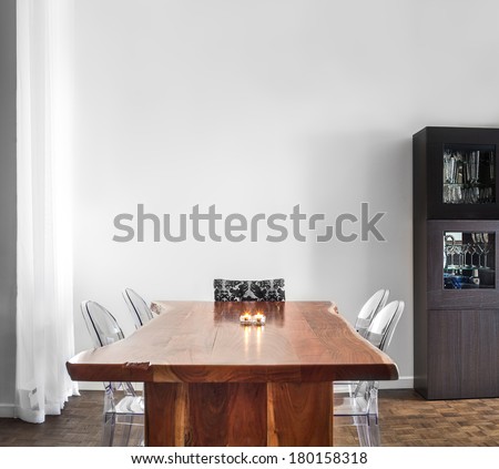 Modern and Contemporary dining room table and decorations with blank wall for your text, image or logo.
