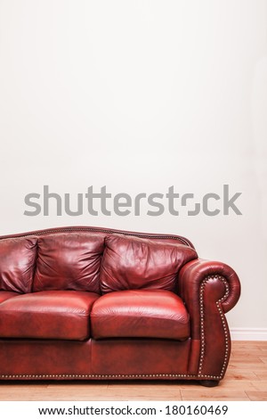 Luxurious Red Leather Couch in front of a blank wall to ad your text, logo, images, etc.