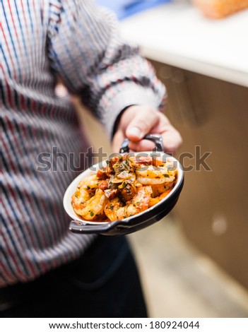 Man presenting a Traditional Portuguese Shrimp Meal in a restaurant Kitchen