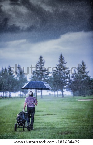 Golfer on a Rainy Day Leaving the Golf Course (the game is annulled because of the storm)