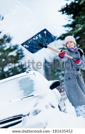 Car Stuck in the snow and a Woman Shoveling after a big Snowstorm