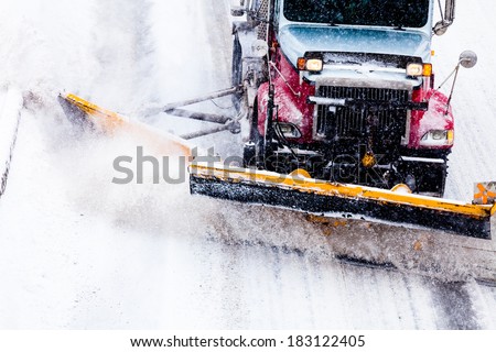 Snowplow Truck Removing the Snow from the Highway during a Cold Snowstorm Winter Day