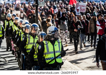 MONTREAL, CANADA   APRIL 02 2015: Riot in the Montreal Streets to counter the Economic Austerity Measures. Cops Following the Marchers to make sure everything is under Control