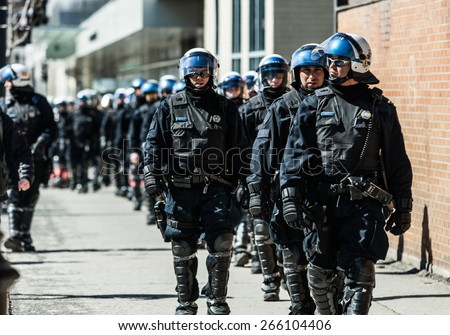 MONTREAL, CANADA   APRIL 02 2015: Riot in the Montreal Streets to counter the Economic Austerity Measures. Cops Following Marchers in case of something Goes Wrong