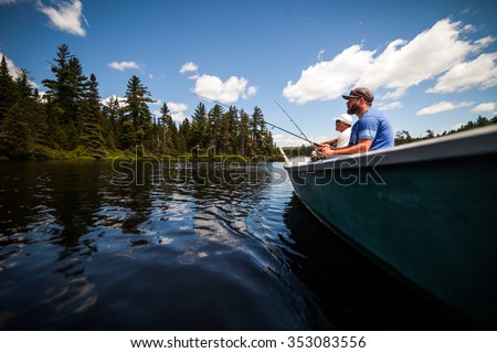 Sun and Father Fishing in a Calm Lake in Wild Nature from a Boat.