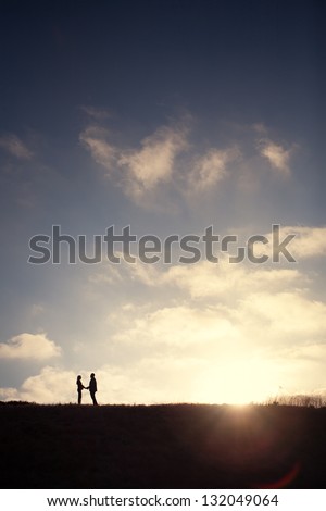 Couple Holding Hands at Sunset Silhouette