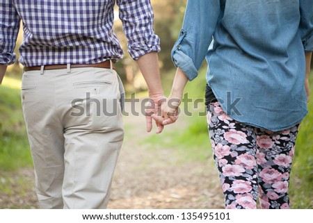 Couple holding hands walking away