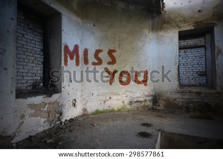 text miss you on the dirty old wall in an abandoned ruined house