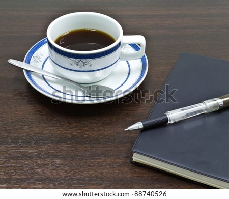 cup of coffee and notebook on meeting table