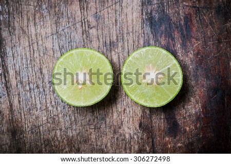 Green Lemon cut on wooden background