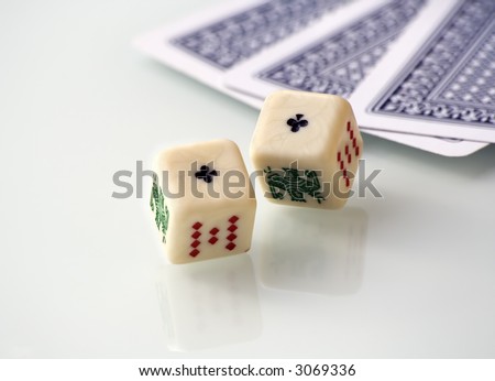 Some poker games: cards and dices, over a white reflecting table.