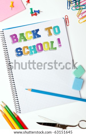 Set of pencils, erasers, post-its and other useful supplies for the school. There is a centered blank notebook for text writing with the title of Back to School