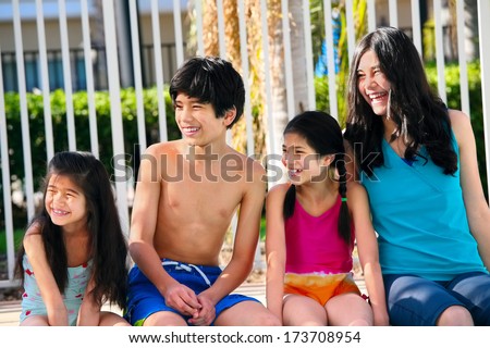 Four children, siblings,  enjoying the pool together