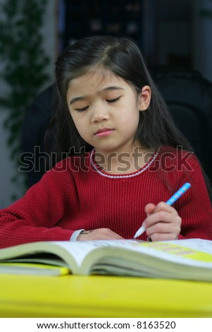 Six year old girl doing her homework at night.