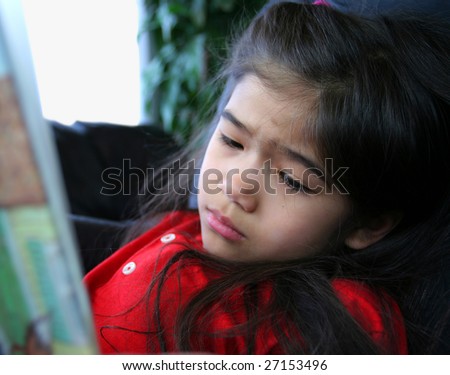 GIrl reading a story, looking sad at the sad part of story