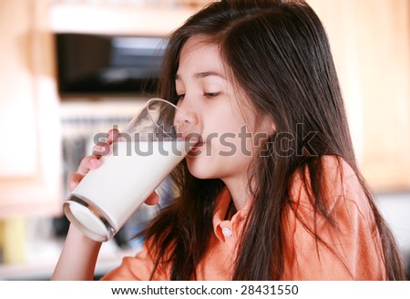 Girl drinking milk in kitchen