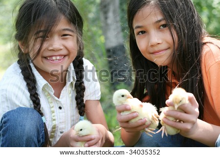 Two happy girls holding their pet chicks