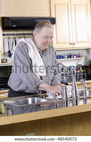 Elderly man washing dishes
