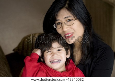Mother holding disabled son with cerebral palsy