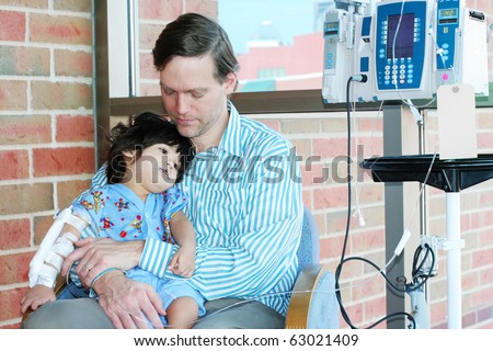 Worried father holding sick child in Hospital