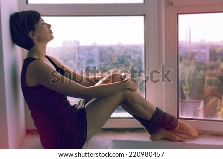 A girl day dreaming near the window. Image in retro style.