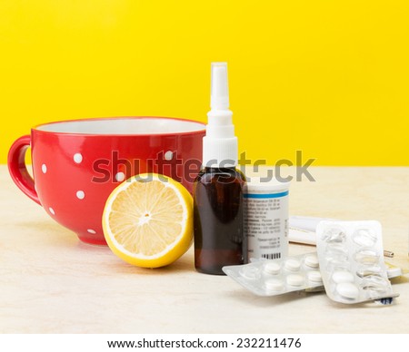Laptop and cold medicine on a yellow background