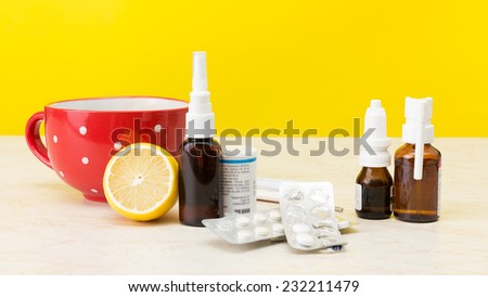 Laptop and cold medicine on a yellow background