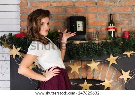 Two beautiful girl friends playing chess by the fireplace