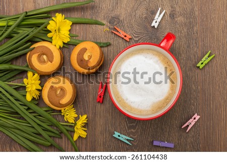 Cappuccino in red mug with delicious cookies and decor
