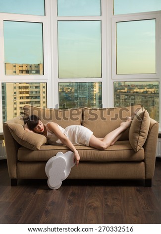 Girl dreaming with a white cloud on a couch