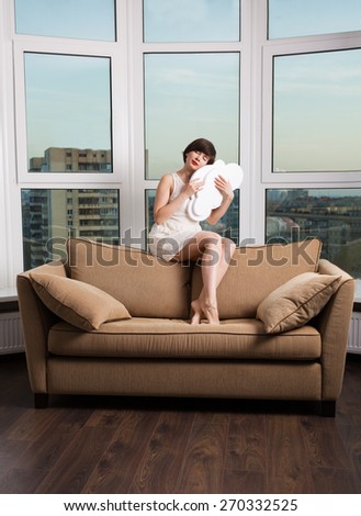 Girl dreaming with a white cloud on a couch