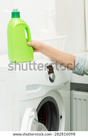 Bottle of detergent standing on a washing machine