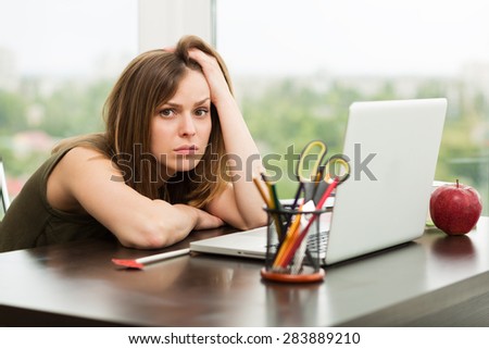 Beautiful woman working at the laptop in the office