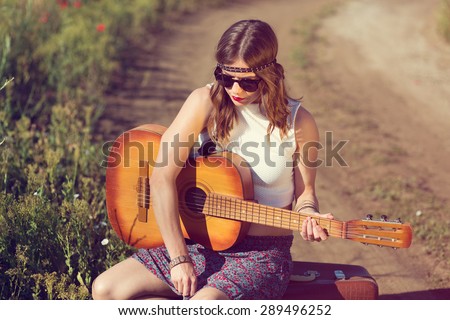 Beautiful hippie girl alone on the countryside road