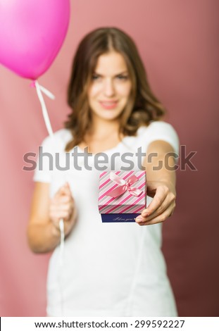Beautiful surprised girl with a gift box