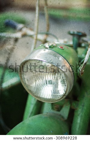 Green vintage motorbike headlamp. Textured image