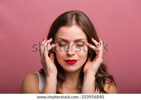 Beautiful young woman applying an eye cream