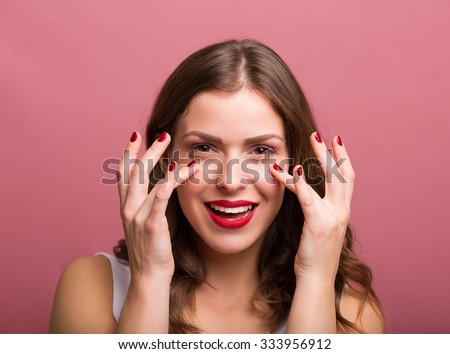 Beautiful young woman applying an eye cream