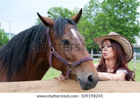 Beautiful brunette girl speaks with a horse