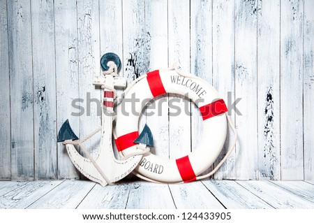 Anchor And Life Buoy On A Background Of White Shabby Wall Boards.