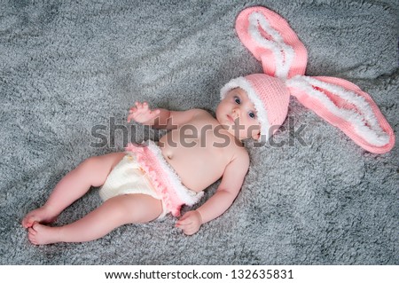 Small child with rabbit ears. Lying on your back with carrots.