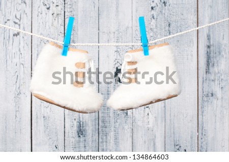 Children\'s boots hanging on a clothesline.