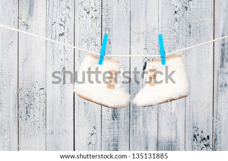 Children\'s boots hanging on a clothesline.