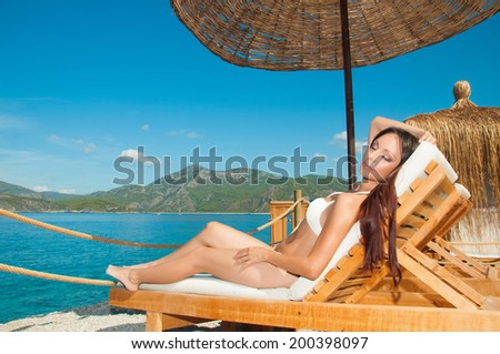 Girl sunbathing in VIP bungalow overlooking the sea
