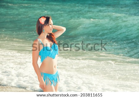 Slim beautiful woman on the sea coast looking  into distance