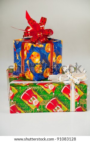 Two New Year's gifts in festive packaging. Blue box with red ribbon, green box with white  ribbon