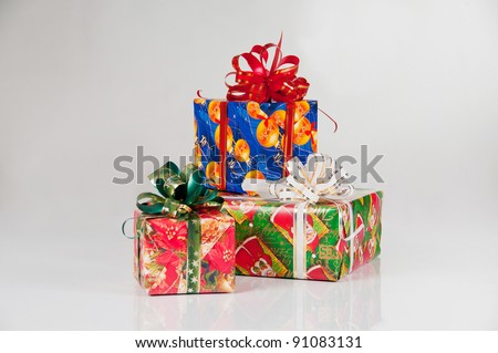 Three New Year\'s gifts in festive packaging. Red box with green ribbon, blue box with red ribbon, green box with white  ribbon