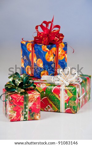 Three New Year\'s gifts in festive packaging. Red box with green ribbon, blue box with red ribbon, green box with white  ribbon